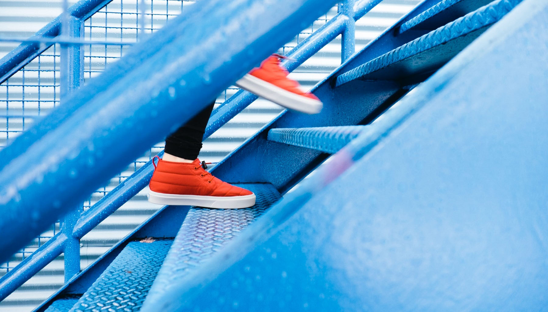 Someone climbing up blue stairs