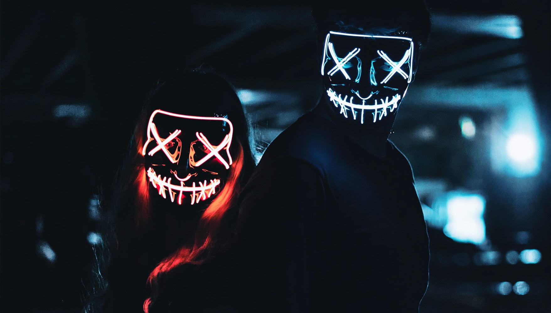 Two surreal people wearing LED masks depicting toxicity.